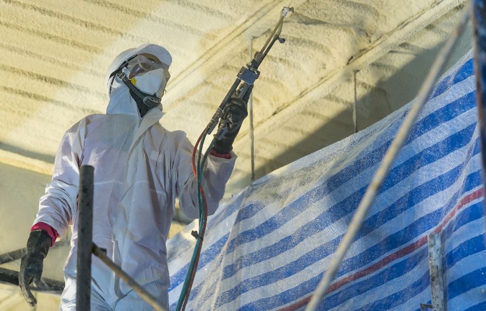 A contractor spraying foam